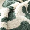 Interior cotton rug with dark green speckled pattern and fringes