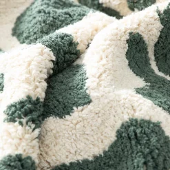 Interior cotton rug with dark green speckled pattern and fringes
