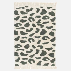 Interior cotton rug with dark green speckled pattern and fringes