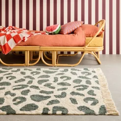 Interior cotton rug with dark green speckled pattern and fringes
