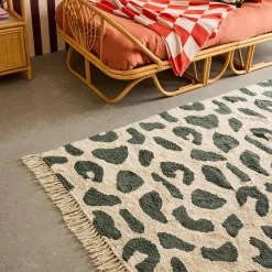 Interior cotton rug with dark green speckled pattern and fringes