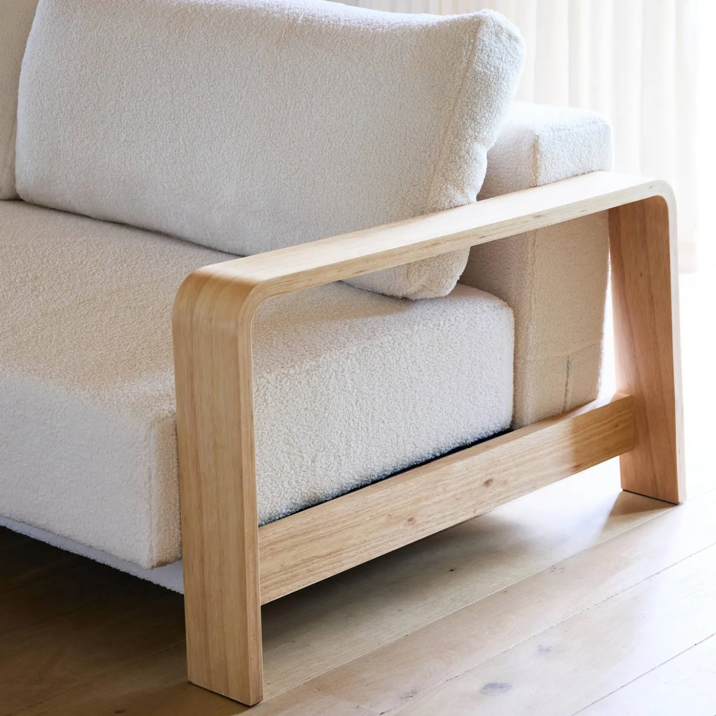3-seater sofa bed in white boucle with wooden armrests