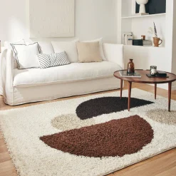 Shaggy indoor rug with circular patterns in beige, brown, black