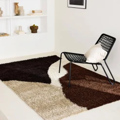 Shaggy indoor rug with geometric patterns in beige, brown and black